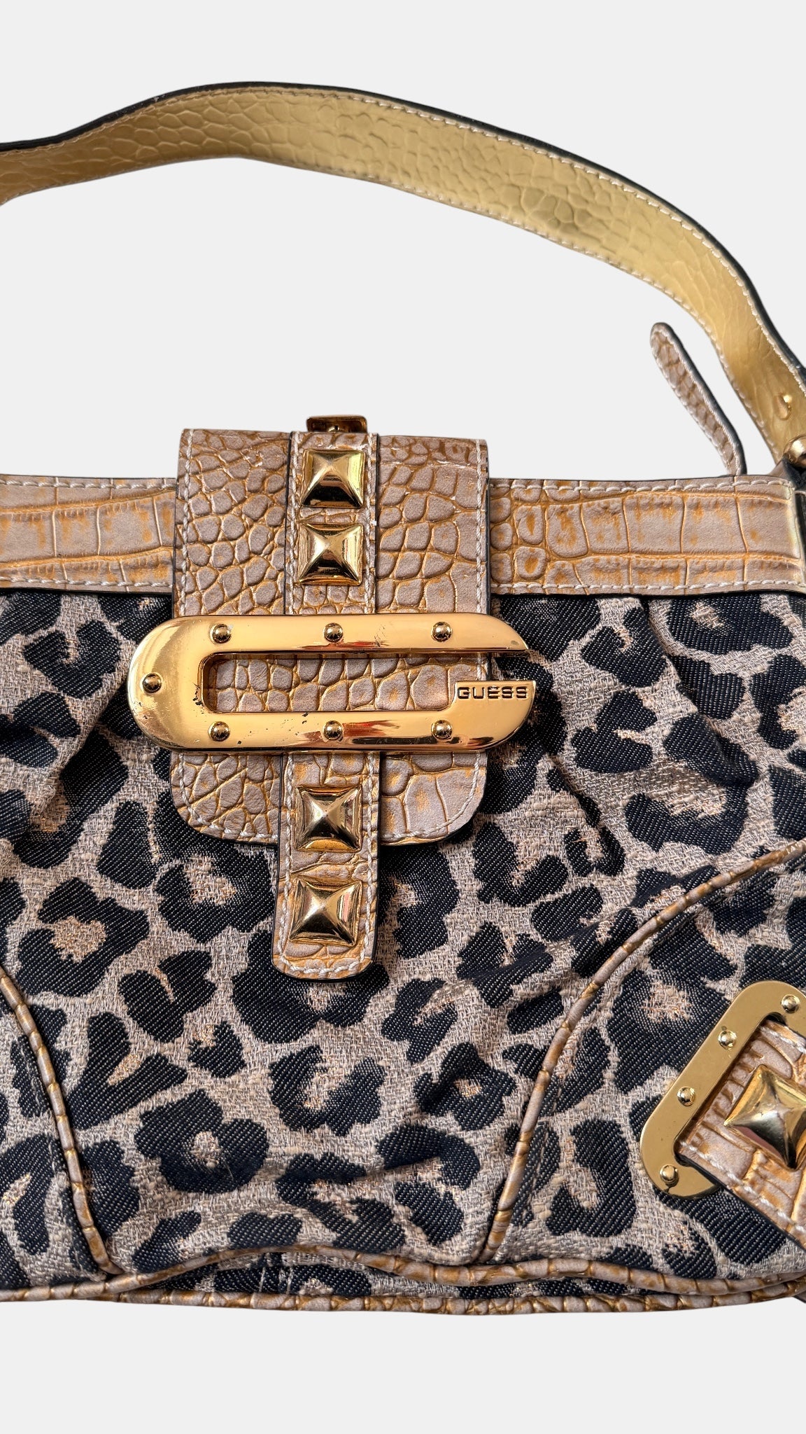 Detailaufnahme des Guess-Verschlusses in Gold