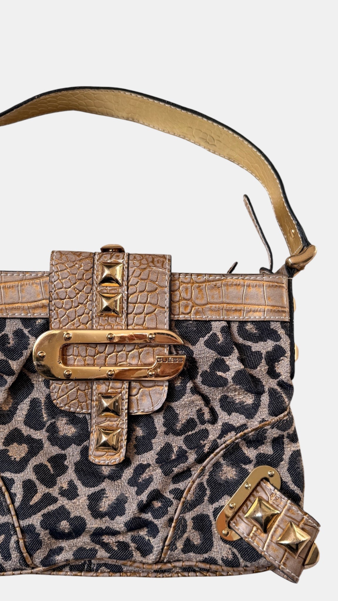 Detailaufnahme des Guess-Verschlusses in Gold
