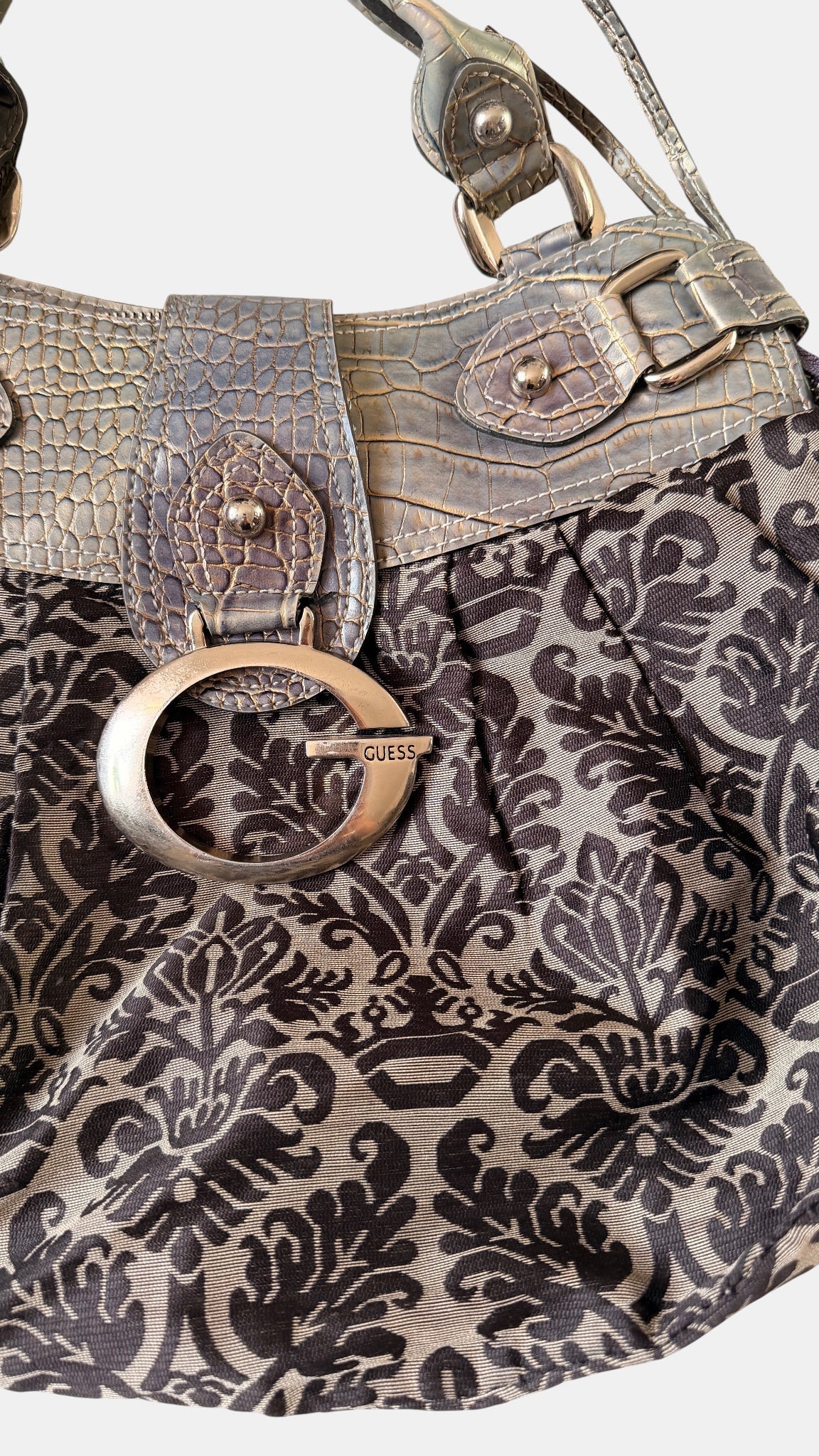 Detailaufnahme des Guess-Logos an der Vintage Schultertasche
