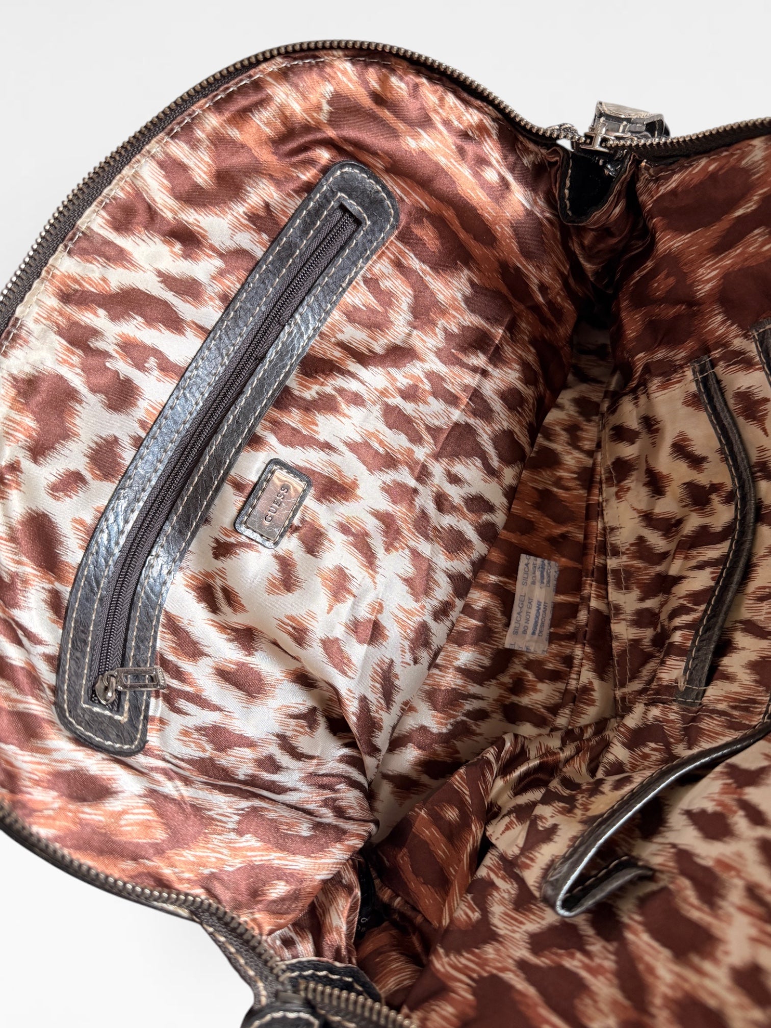 Vintage Guess Handtasche mit Monogramm-Muster, Reissverschlussfach und silberfarbenen Details
