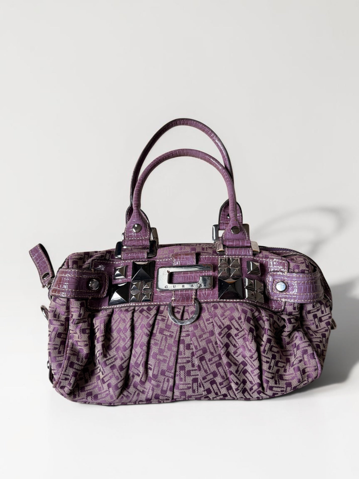 Lila Vintage Guess Handtasche mit Monogramm-Muster, Kroko-Details, silberfarbenen Nieten und Guess-Logo