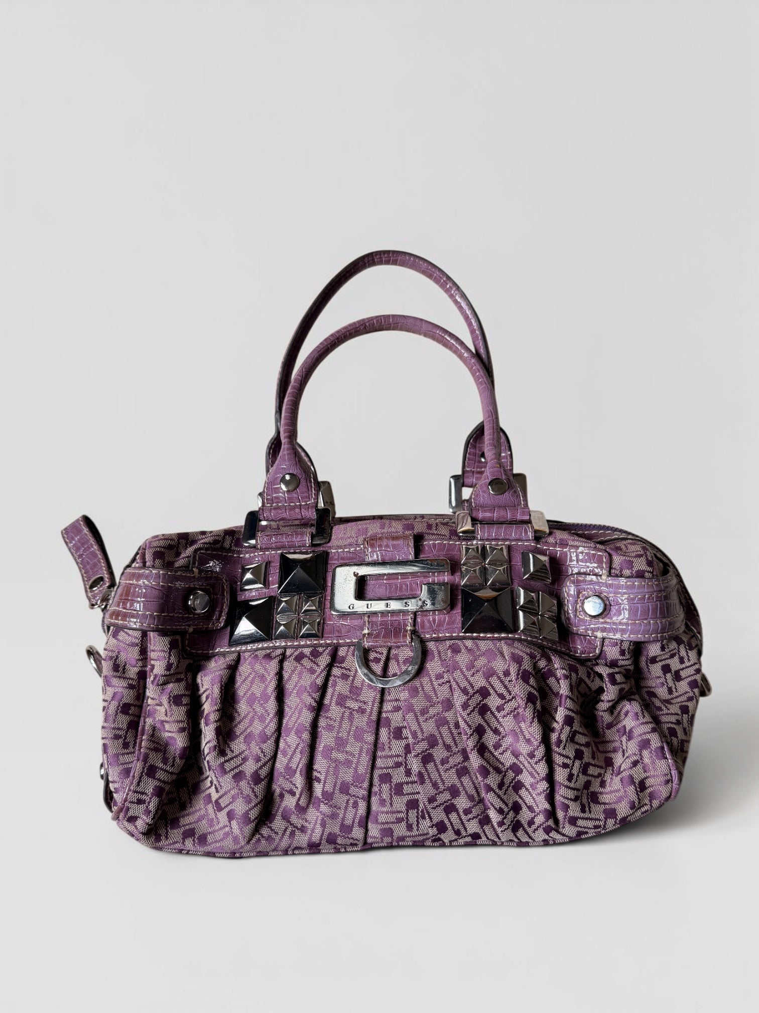 Lila Vintage Guess Handtasche mit Monogramm-Muster, Kroko-Details, silberfarbenen Nieten und Guess-Logo