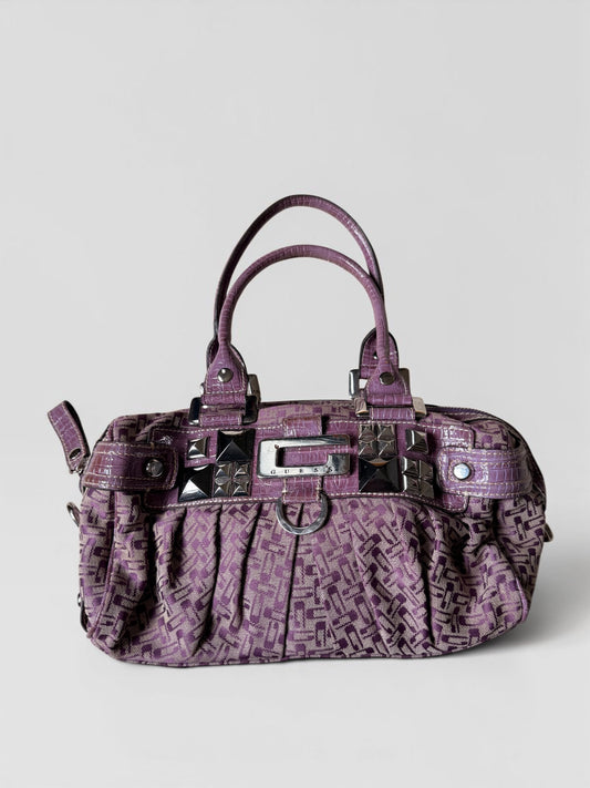 Lila Vintage Guess Handtasche mit Monogramm-Muster, Kroko-Details, silberfarbenen Nieten und Guess-Logo