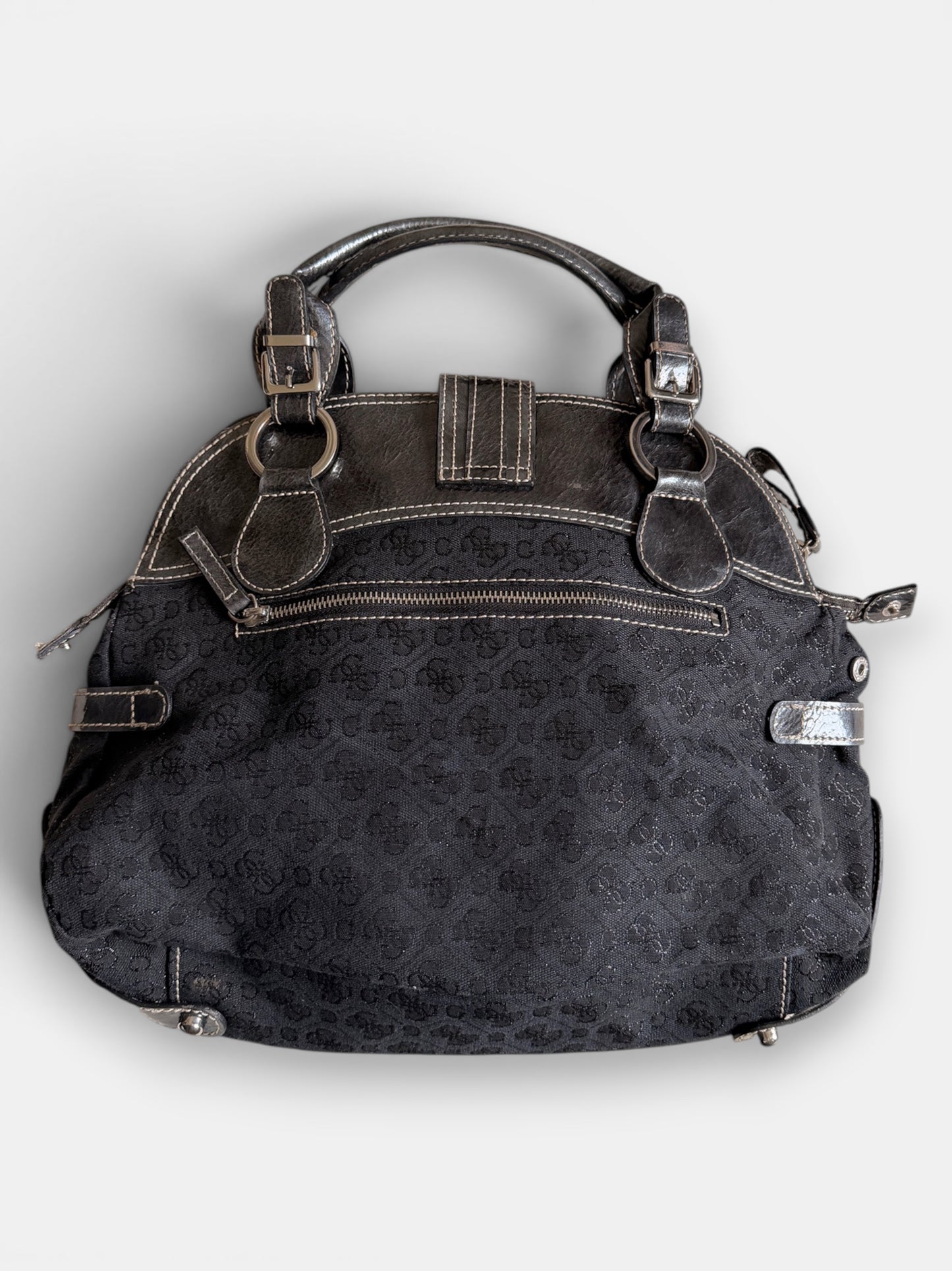 Rückseite einer schwarzen Vintage Guess Handtasche mit Monogramm-Muster, Reissverschlussfach und silberfarbenen Details
